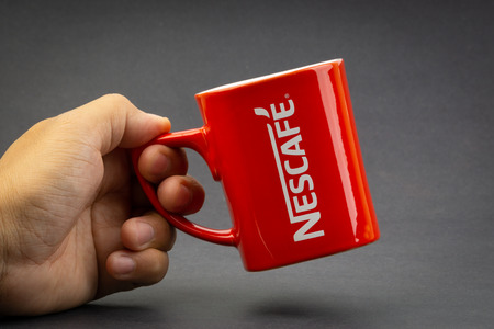 Kuala Lumpur, Malaysia - July 03, 2019; Promotional red Nescafe mug on dark background. Selective focusのeditorial素材