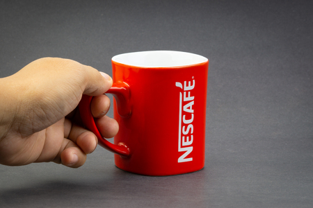 Kuala Lumpur, Malaysia - July 03, 2019; Promotional red Nescafe mug on dark background. Selective focusのeditorial素材