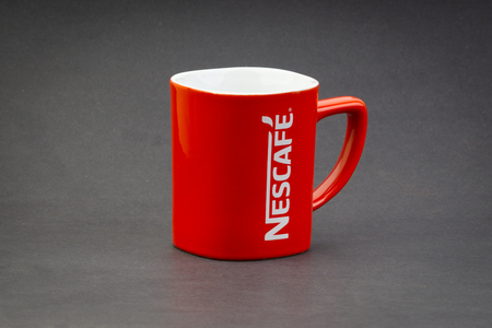 Kuala Lumpur, Malaysia - July 03, 2019; Promotional red Nescafe mug on dark background. Selective focusのeditorial素材