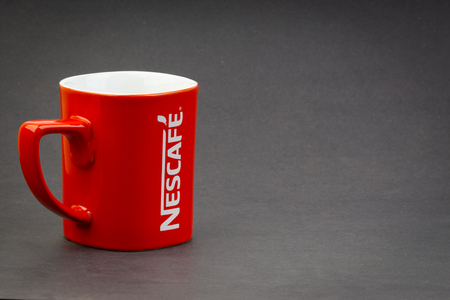 Kuala Lumpur, Malaysia - July 03, 2019; Promotional red Nescafe mug on dark background. Selective focusのeditorial素材
