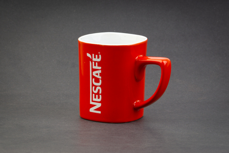 Kuala Lumpur, Malaysia - July 03, 2019; Promotional red Nescafe mug on dark background. Selective focusのeditorial素材
