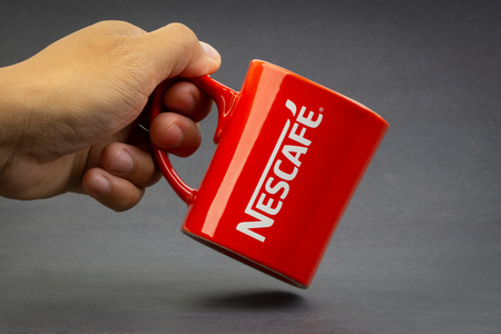 Kuala Lumpur, Malaysia - July 03, 2019; Promotional red Nescafe mug on dark background. Selective focusのeditorial素材