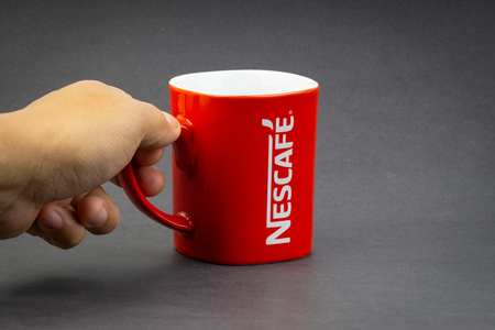 Kuala Lumpur, Malaysia - July 03, 2019; Promotional red Nescafe mug on dark background. Selective focusのeditorial素材