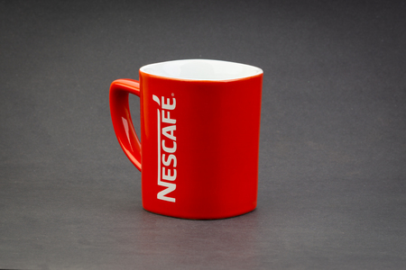 Kuala Lumpur, Malaysia - July 03, 2019; Promotional red Nescafe mug on dark background. Selective focusのeditorial素材