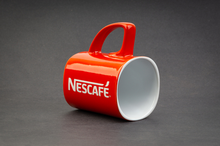 Kuala Lumpur, Malaysia - July 03, 2019; Promotional red Nescafe mug on dark background. Selective focusのeditorial素材