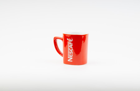 Kuala Lumpur, Malaysia - July 03, 2019:  Promotional red Nescafe mug on white background. Selective focusのeditorial素材