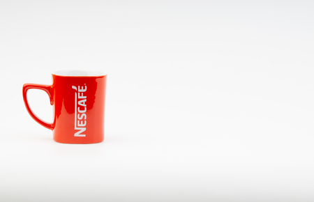 Kuala Lumpur, Malaysia - July 03, 2019:  Promotional red Nescafe mug on white background. Selective focusのeditorial素材