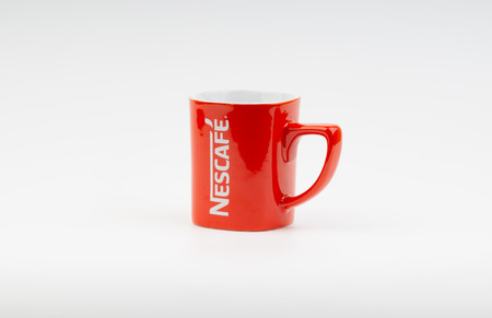 Kuala Lumpur, Malaysia - July 03, 2019:  Promotional red Nescafe mug on white background. Selective focusのeditorial素材