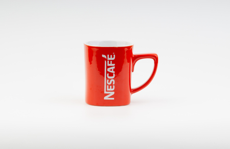 Kuala Lumpur, Malaysia - July 03, 2019:  Promotional red Nescafe mug on white background. Selective focusのeditorial素材