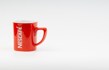Kuala Lumpur, Malaysia - July 03, 2019:  Promotional red Nescafe mug on white background. Selective focusのeditorial素材