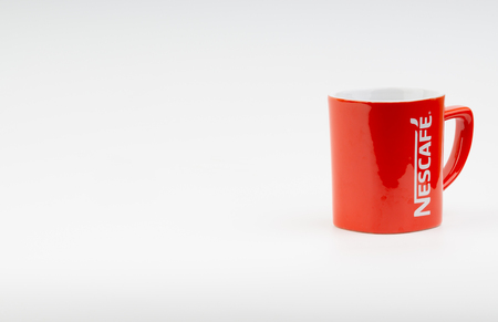 Kuala Lumpur, Malaysia - July 03, 2019:  Promotional red Nescafe mug on white background. Selective focusのeditorial素材