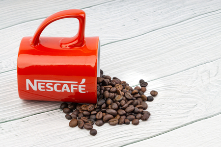 Kuala Lumpur, Malaysia - July 03, 2019: Promotional red Nescafe mug on wooden background. Selective focusのeditorial素材