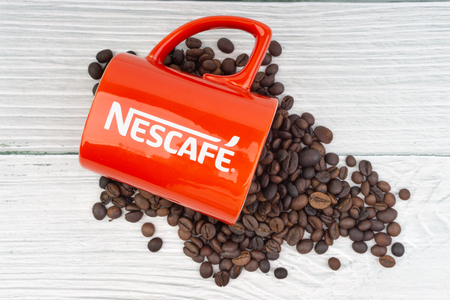 Kuala Lumpur, Malaysia - July 03, 2019: Promotional red Nescafe mug on wooden background. Selective focusのeditorial素材
