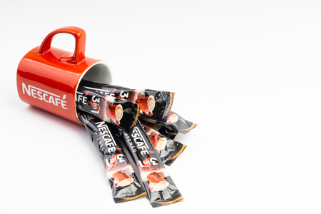 Kuala Lumpur, Malaysia - July 2, 2019: Sachet of instant Intenso Nescafe coffee with Nescafe mug on...