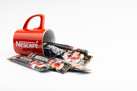 Kuala Lumpur, Malaysia - July 2, 2019: Sachet of instant Intenso Nescafe coffee with Nescafe mug on...