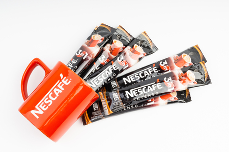 Kuala Lumpur, Malaysia - July 2, 2019: Sachet of instant Intenso Nescafe coffee with Nescafe mug on white background. Selective focusのeditorial素材