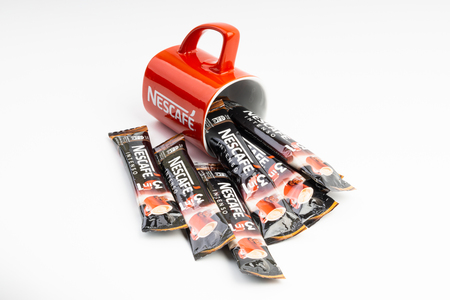 Kuala Lumpur, Malaysia - July 2, 2019: Sachet of instant Intenso Nescafe coffee with Nescafe mug on white background. Selective focusのeditorial素材