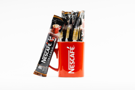 Kuala Lumpur, Malaysia - July 2, 2019: Sachet of instant Intenso Nescafe coffee with Nescafe mug on...