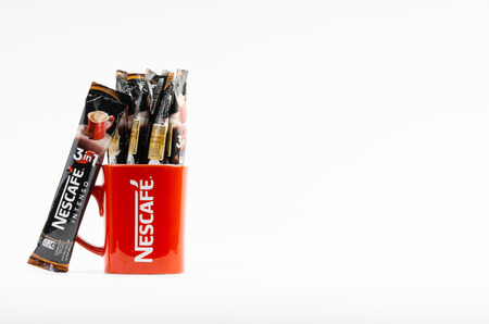 Kuala Lumpur, Malaysia - July 2, 2019: Sachet of instant Intenso Nescafe coffee with Nescafe mug on white background. Selective focusのeditorial素材
