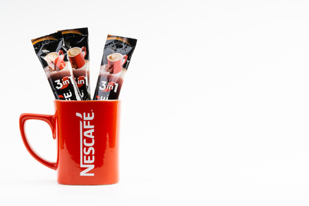 Kuala Lumpur, Malaysia - July 2, 2019: Sachet of instant Intenso Nescafe coffee with Nescafe mug on white background. Selective focusのeditorial素材