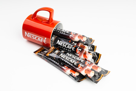 Kuala Lumpur, Malaysia - July 2, 2019: Sachet of instant Intenso Nescafe coffee with Nescafe mug on white background. Selective focusのeditorial素材