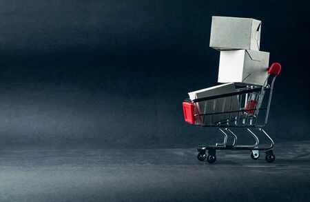 Shopping cart and box on dark background, business, shopping concept. Selective focus