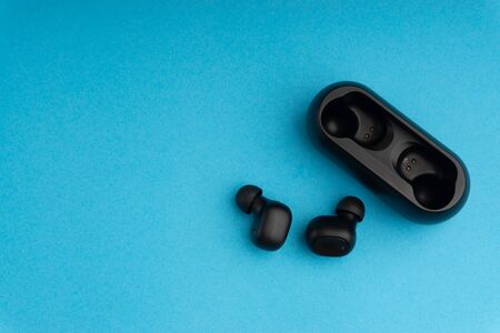 Wireless earbuds or earphones on blue backgroundの写真素材