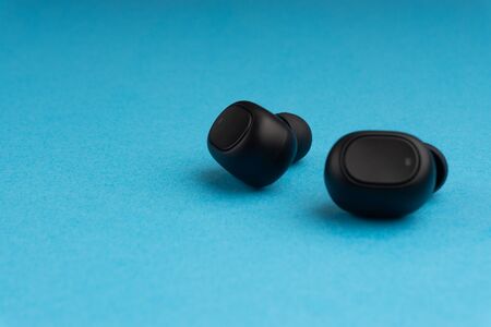 Wireless earbuds or earphones on blue backgroundの写真素材