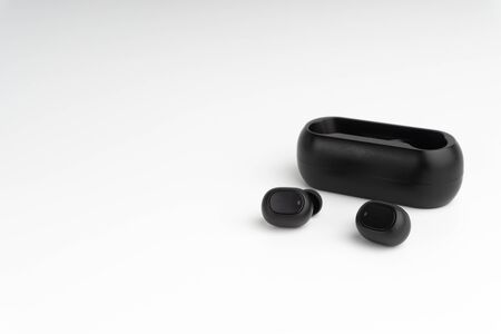 Wireless earbuds or earphones on white background. Copy space and technology conceptの写真素材