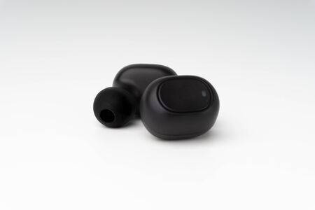Wireless earbuds or earphones on white background. Copy space and technology concept