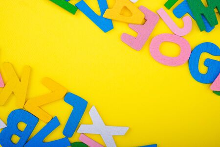 ABC wooden letters alphabet scattered on a yellow background. Education and copy spaceの写真素材