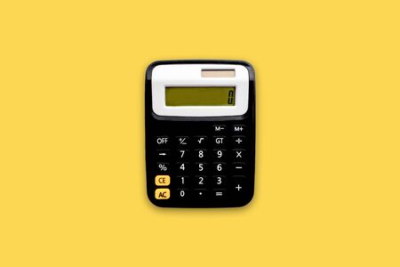 Calculator on yellow background. Business and copy space conceptの写真素材