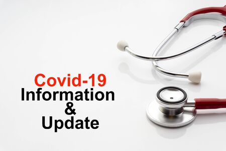 COVID-19 INFORMATION AND UPDATE text with stethoscope on white background. Covid or Coronavirus Conceptの写真素材