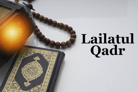 LAILATUL QADR text with Holy Al Quran with written arabic calligraphy meaning of Al Quran and rosary beads or tasbih on white background.の写真素材