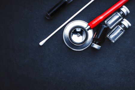 Medical swab, vials and stethoscope closeup on black background. Health care and copy space conceptの写真素材