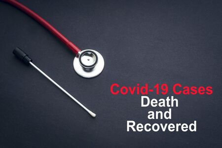 COVID-19 or CORONAVIRUS DEATH AND RECOVERED text with stethoscope and medical swab on black background. Covid-19 or Coronavirus concept.の写真素材