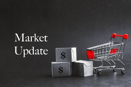 Shopping cart with words MARKET UPDATE on dark background. Business, Copy space and online shopping concept. Selective focusの写真素材