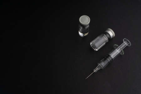 Closeup syringe and vials on black background. Healthcare dan Copy Space conceptの写真素材