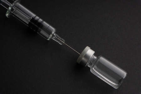 Closeup syringe and vials on black background. Healthcare dan Copy Space conceptの写真素材