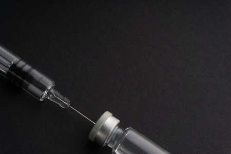 Closeup syringe and vials on black background. Healthcare dan Copy Space conceptの写真素材