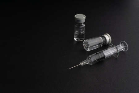 Closeup syringe and vials on black background. Healthcare dan Copy Space conceptの写真素材