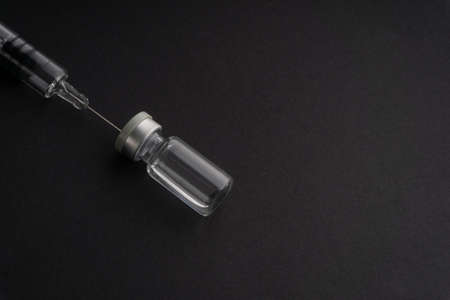 Closeup syringe and vials on black background. Healthcare dan Copy Space conceptの写真素材