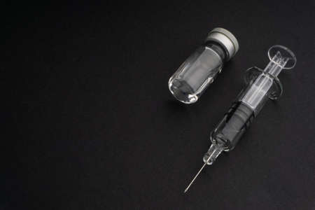 Closeup syringe and vials on black background. Healthcare dan Copy Space conceptの写真素材