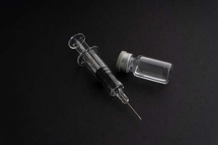 Closeup syringe and vials on black background. Healthcare dan Copy Space conceptの写真素材
