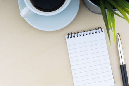 Fountain pen, decorative plant, notepad and cup of coffee on wooden background. Business and copy space concept.の写真素材
