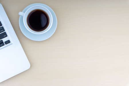 Laptop and cup of coffee on wooden background. Business and copy space concept.の写真素材