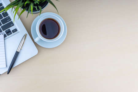Laptop, notepad, fountain pen, decorative plant and cup of coffee on wooden background. Business and copy space concept.の写真素材