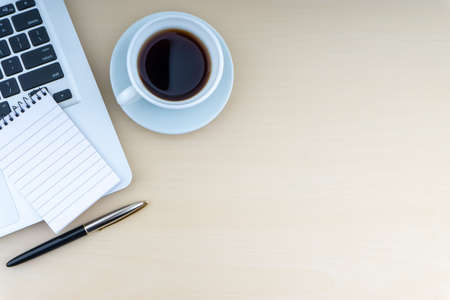 Laptop, notepad, fountain pen and cup of coffee on wooden background. Business and copy space concept.の写真素材