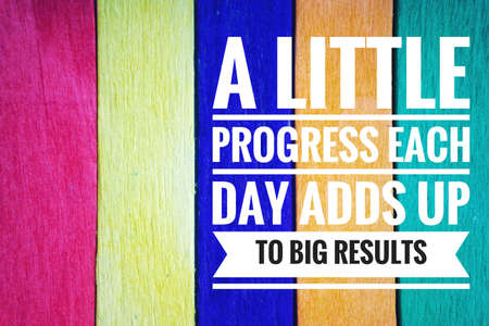 A LITTLE PROGRESS EACH DAY ADDS UP TO BIG RESULTS text and colorful wooden stick backgroundの写真素材