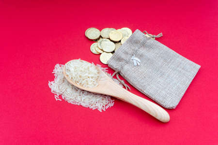 Coins and rice on red background. Zakat concept. Zakat is a form of alm-giving as a religious...